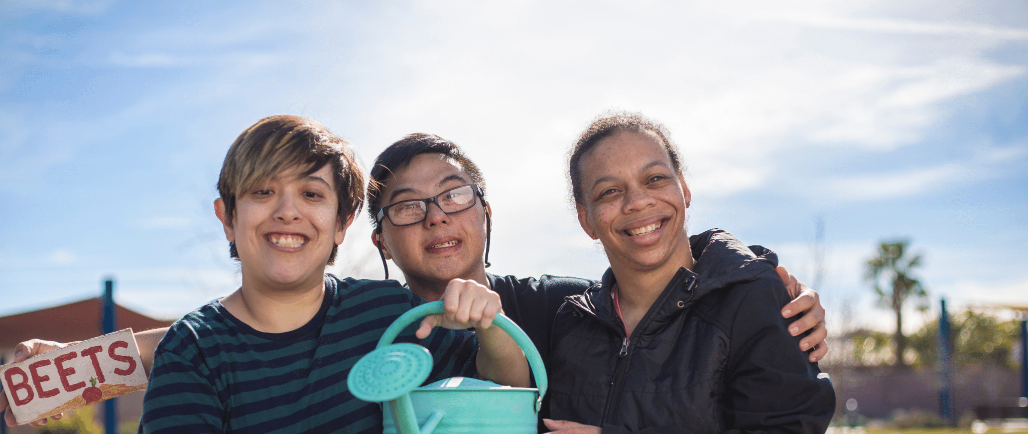 Three, young people from diverse backgrounds smiling
