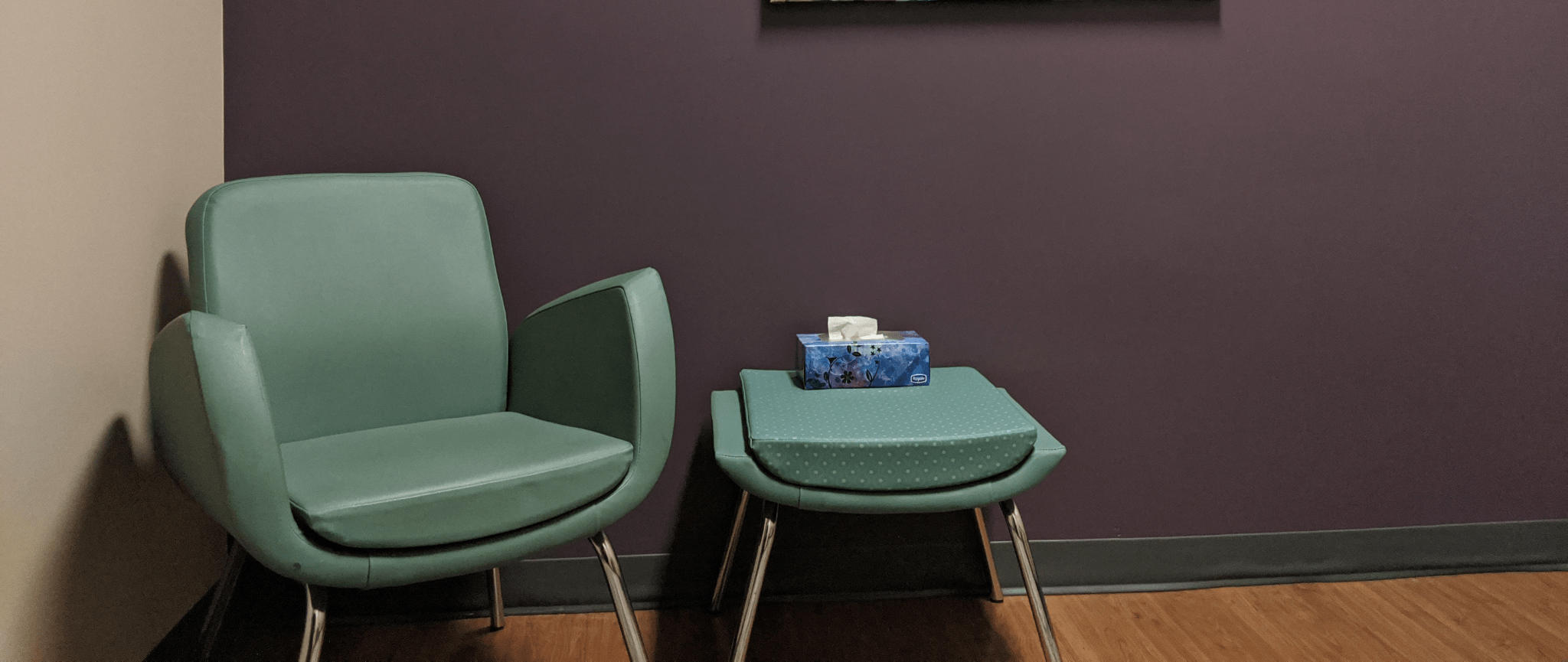 A green chair and floral painting inside an FSWE counselling office